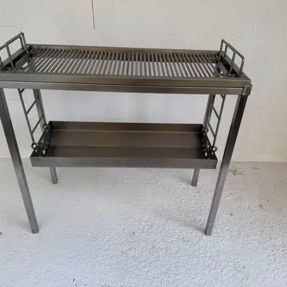 Braai stand: Dark steel stand with ladder rails and hanging ash pan.
