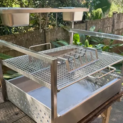 Custom wood-fired grill: Perforated firebox, warmer trays and grill basket in 304 stainless.