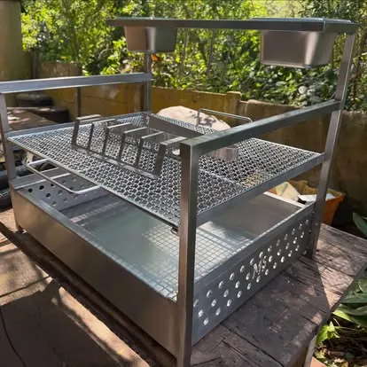 Custom wood-fired grill: Adjustable grill basket over a deep fire bed.
