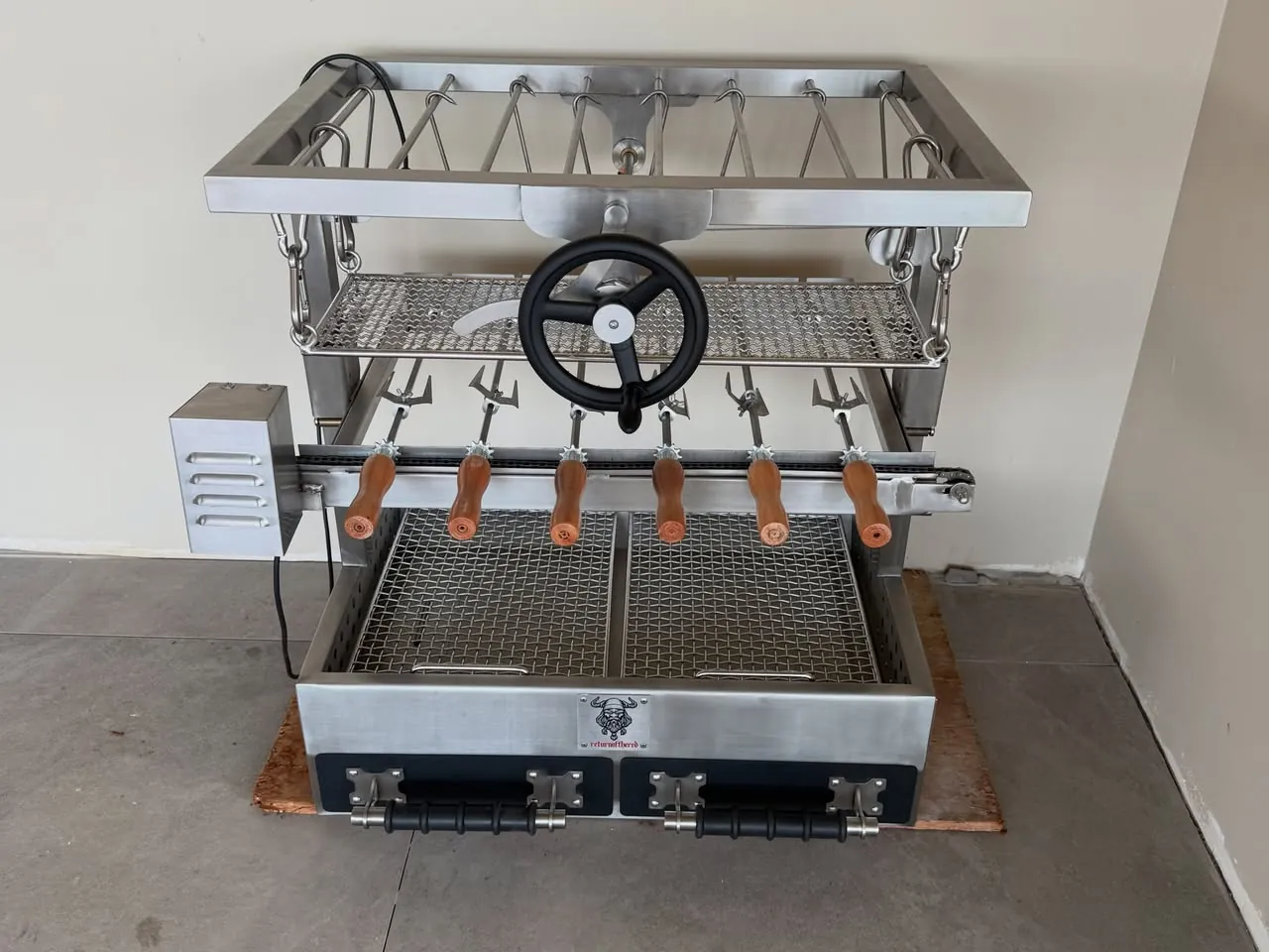 Single wheel Argentinian grill with rotisserie skewers
